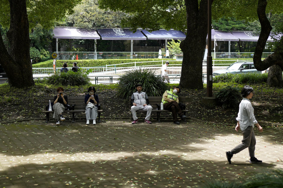 People rest in shade at a park in Tokyo, Friday, July 7, 2023, in Tokyo. Hot weather continues in the metro area as temperatures rise to 32 degrees Celsius (89 degrees Fahrenheit), according to Japan's meteorological bureau. (AP Photo/Shuji Kajiyama)