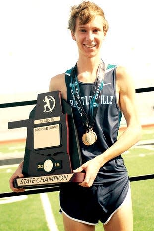 Henry Williams hoists the Bartlesville team's state cross-country championship award in 2016.