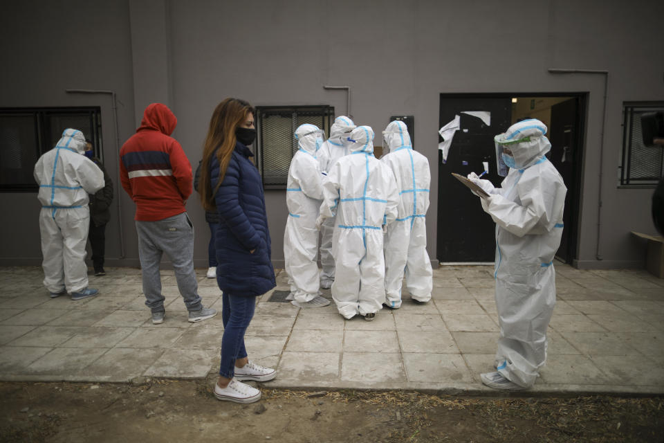 Trabajadores de la salud entrevistan a residentes en el barrio de Villa Azul el lunes 25 de mayo de 2020 en las afueras de Buenos Aires, Argentina. El vecindario fue aislado en medio de una cuarentena después de que más de 50 residentes dieron positivo al coronavirus, según autoridades. (Foto AP/Natacha Pisarenko)