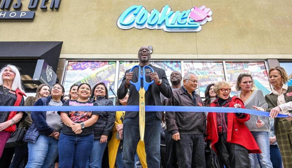 Kevin Jordan, center, franchise owner of Cookie Plug, gets ready to cut a ribbon for the company’s new store at Fresno State’s Campus Pointe shopping center during its event. CRAIG KOHLRUSS/ckohlruss@fresnobee.com