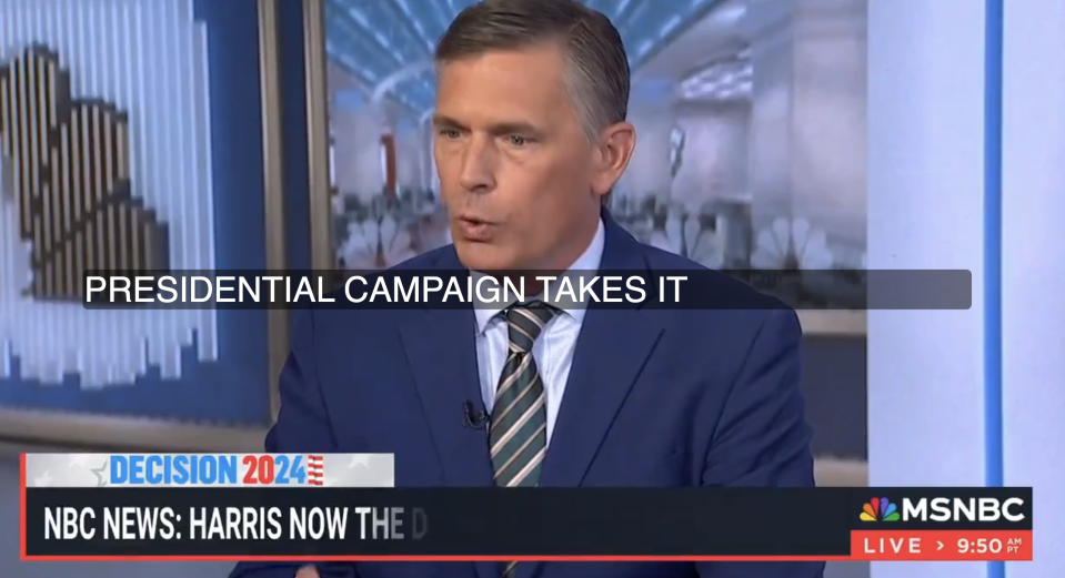 A man in a blue suit and striped tie speaks on an MSNBC news broadcast about a presidential campaign. The screen reads, "NBC News: Harris Now the D..."