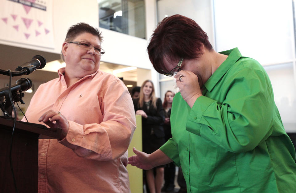 Jayne Rowse, left, looks at April DeBoer as she reacts during a news conference in Ferndale, Mich., Friday, March 21, 2014. A federal judge struck down Michigan's ban on gay marriage Friday, the latest in a series of decisions overturning similar laws across the U.S. The two nurses who've been partners for eight years claimed the ban violated their rights under the U.S. Constitution. (AP Photo/Paul Sancya)