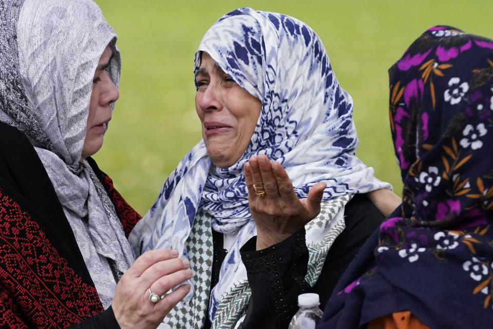 Muslim community members cry at the grave of Wadea Al Fayoume in LaGrange, Ill., Monday, Oct. 16, 2023. An Illinois landlord accused of fatally stabbing the 6-year-old Muslim boy and seriously wounding his mother was charged with a hate crime after police and relatives said he singled out the victims because of their faith and as a response to the war between Israel and Hamas. (AP Photo/Nam Y. Huh)