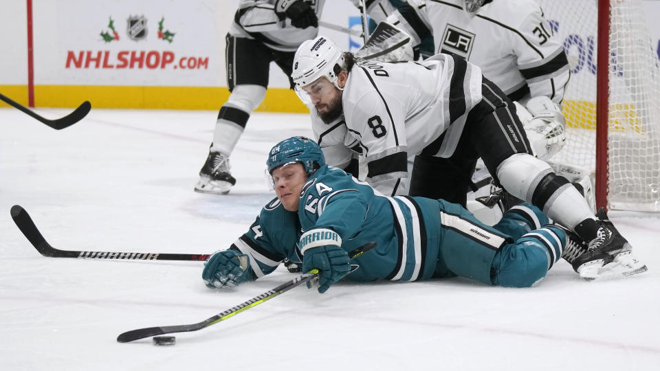 San Jose Sharks center Mikael Granlund (64) reaches for the puck in front Los Angeles Kings defenseman Drew Doughty (8) during the first period of an NHL hockey game in San Jose, Calif., Tuesday, Dec. 19, 2023. (AP Photo/Jeff Chiu)