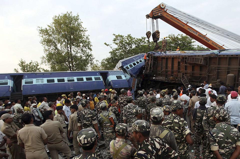 Security personnel and rescue members stand next to damaged coaches of a passenger train after a collision in Khalilabad in the northern Indian state of Uttar Pradesh May 26, 2014. (REUTERS/Stringer)