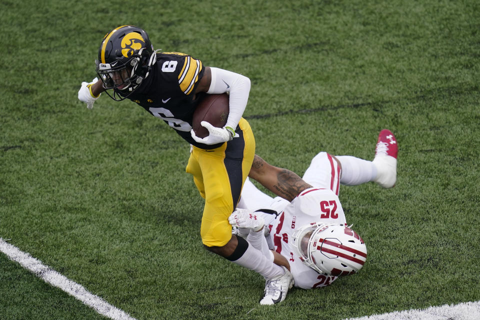 Iowa wide receiver Ihmir Smith-Marsette (6) is tackled by Wisconsin safety Eric Burrell (25) during the first half of an NCAA college football game, Saturday, Dec. 12, 2020, in Iowa City, Iowa. (AP Photo/Charlie Neibergall)