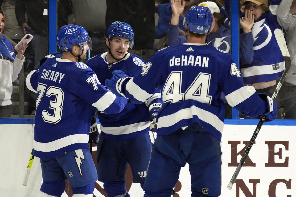 Tampa Bay Lightning center Michael Eyssimont (23) celebrates with left wing Conor Sheary (73) and defenseman Calvin de Haan (44) after scoring against the Vancouver Canucks during the second period of an NHL hockey game Thursday, Oct. 19, 2023, in Tampa, Fla. (AP Photo/Chris O'Meara)