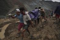 Rescue workers use poles to carry a body shrouded in blue and red plastic sheet Thursday, July 2, 2020, in Hpakant, Kachin State, Myanmar. At least 162 people were killed Thursday in a landslide at a jade mine in northern Myanmar, the worst in a series of deadly accidents at such sites in recent years that critics blame on the government's failure to take action against unsafe conditions. (AP Photo / Zaw Moe Htet)