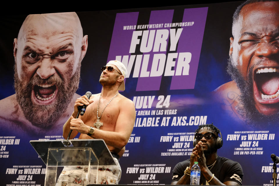 WBC Heavyweight Champion Tyson Fury, left talks during a news conference as Deontay Wilder looks on in Los Angeles on Tuesday, June 15, 2021, in anticipation of their third heavyweight championship showdown scheduled for July 24 in Las Vegas. (AP Photo/Richard Vogel)