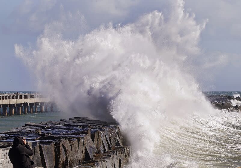 SAN PEDRO, CALIF. - FEB. 22, 2023. A photographer captures a wave crashing into the breakwater at Cabrillo Beach in San Pedro on Wednesday, Feb. 22, 2023. More cold and wet weather, with high winds and surf, are forecast for Southern California as a Canadian cold front moves through the region this week. (Luis Sinco / Los Angeles Times)