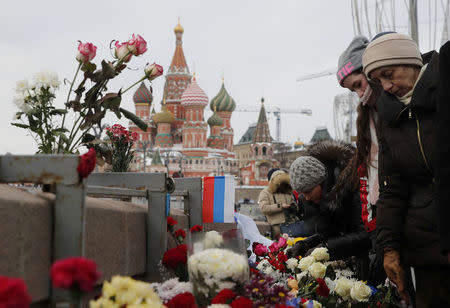 People visit the site of the assassination of Russian opposition leader Boris Nemtsov as they mark the third anniversary of Nemtsov's death, with the St. Basil's Cathedral seen in the background, in central Moscow, Russia February 25, 2018. REUTERS/Maxim Shemetov