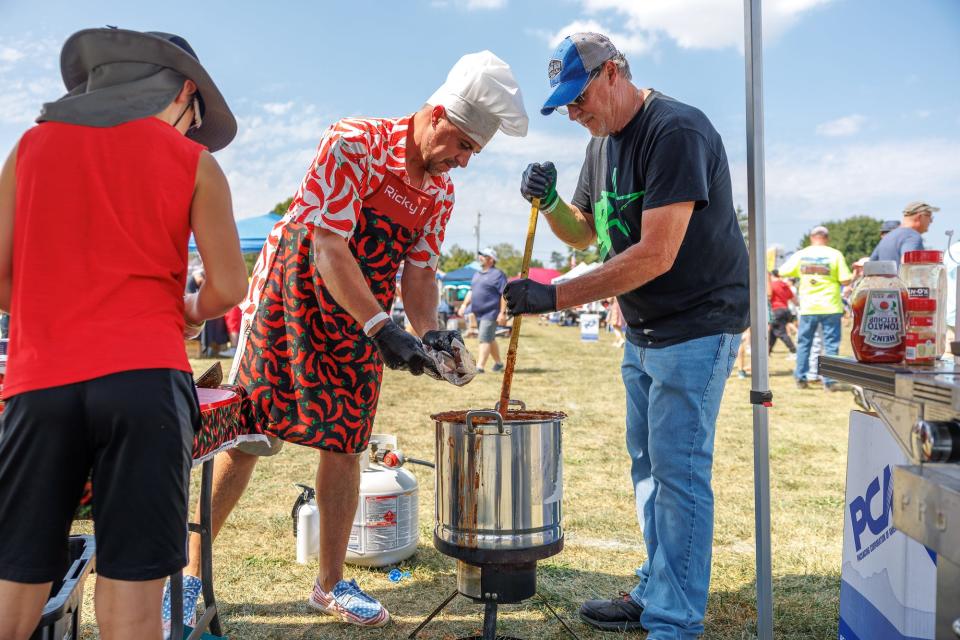 Rick Weaver Jr, of Hanover, second from left, adds ingredients to his chili while his father, Rick Weaver Sr., of Hanover, stirs during the 27th annual Hanover Chili Cookoff, Sunday, Sept. 3, 2023, at Moul Field in Hanover Borough.