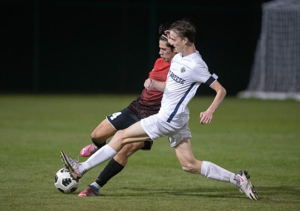 Reynaldo Portugal (14) and Carson Dahlem (20) fight for the ball during the Gulf Breeze vs West Florida boys soccer game at Ashton Brosnaham Park in Pensacola on Wednesday, Dec. 7, 2022.