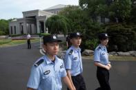 Chinese police officers patrol outside the Xijiao Conference Center in Shanghai, China