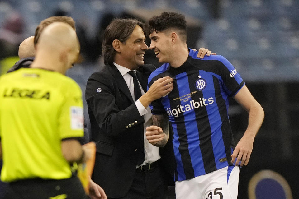 Inter Milan's head coach Simone Inzaghi, left, smiles with his player Alessandro Bastoni during the Italian Super Cup final soccer match between AC Milan and Inter Milan at the King Saud University Stadium, in Riyadh, Saudi Arabia, Wednesday, Jan. 18, 2023. (AP Photo/Hussein Malla)