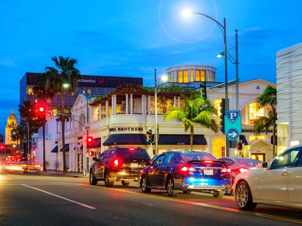 Photo of South Santa Monica Boulevard with businesses and cars in Beverly Hills Los Angeles California USA illuminated at twilight blue hour.