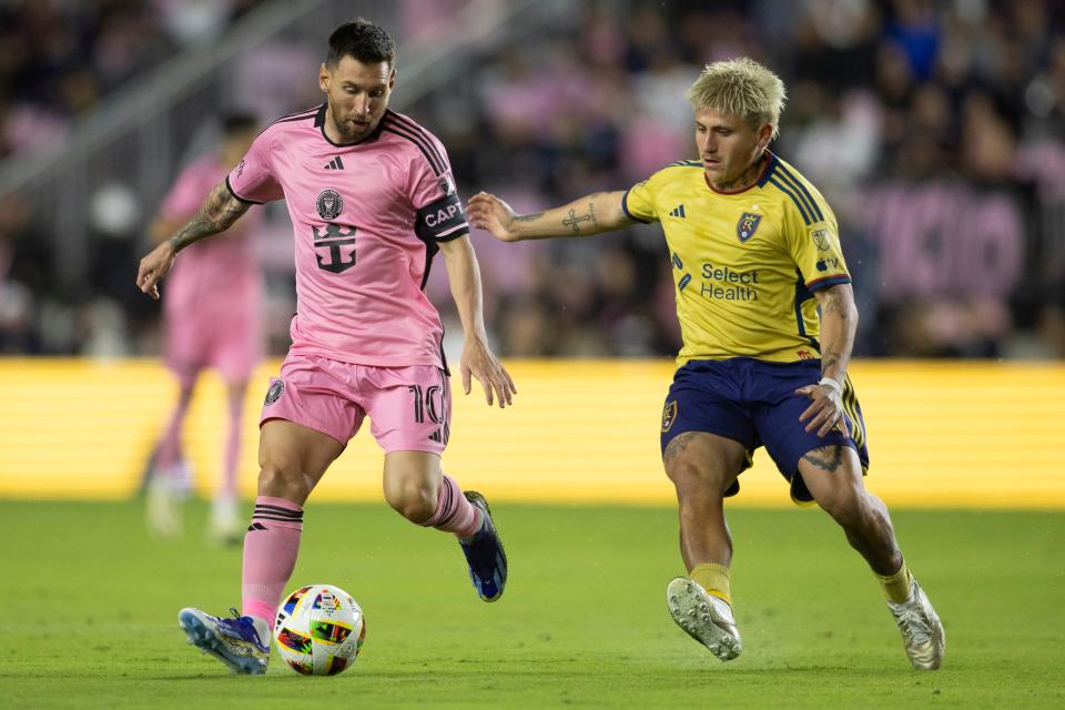 Lionel Messi handles the ball past while Real Salt Lake's Diego Luna defends.