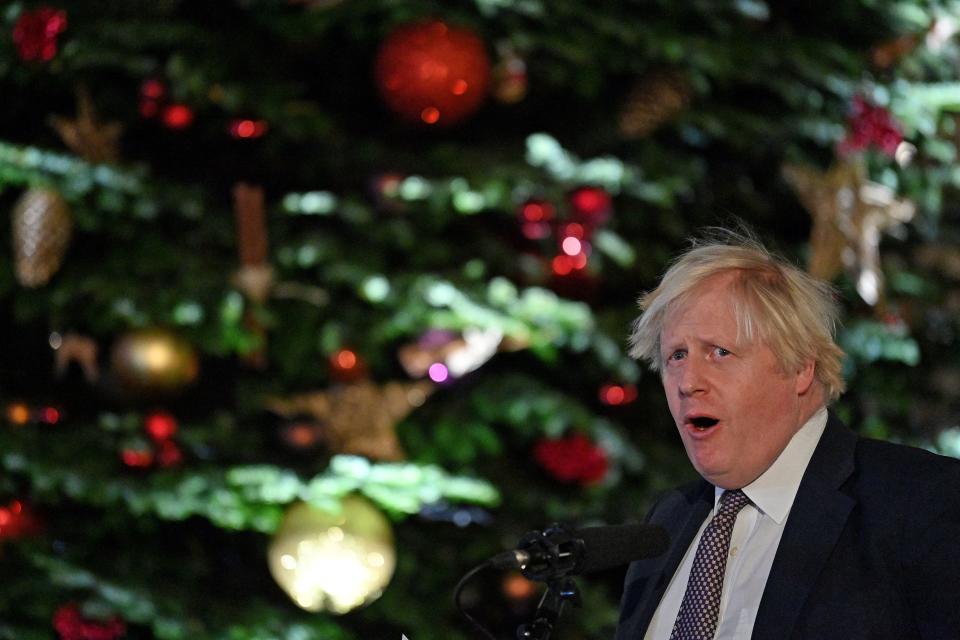 Britain's Prime Minister Boris Johnson stands in front of the Downing Street Christmas tree as he makes a speech at a UK Food and Drinks market set up in Downing Street, central London on November 30, 2021. (Photo by JUSTIN TALLIS / various sources / AFP) (Photo by JUSTIN TALLIS/AFP via Getty Images)