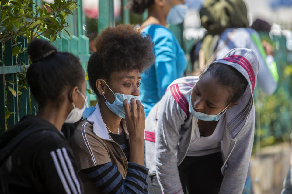 An Ethiopian domestic worker cries as she waits with dozens of others outside the Ethiopian consulate, some inquiring about flights home, others stranded after they were abandoned by employers who claimed they could no longer afford to pay their salaries, in Hazmieh, east of Beirut, Lebanon, Thursday, June 4, 2020. Some 180,000 domestic workers in Lebanon, most of them female from Ethiopia, are growing more desperate as a crippling economic and financial crisis sets in, coupled with coronavirus restrictions. (AP Photo/Hassan Ammar)