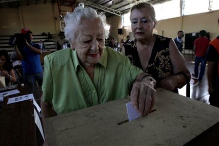 A woman casts her vote at a polling station during the presidential election in Santiago, December 15, 2013. REUTERS/Ivan Alvarado