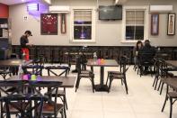 A waiter and diners are seen in a mostly empty Indian restaurant amidst the easing of the coronavirus disease (COVID-19) restrictions, in Sydney