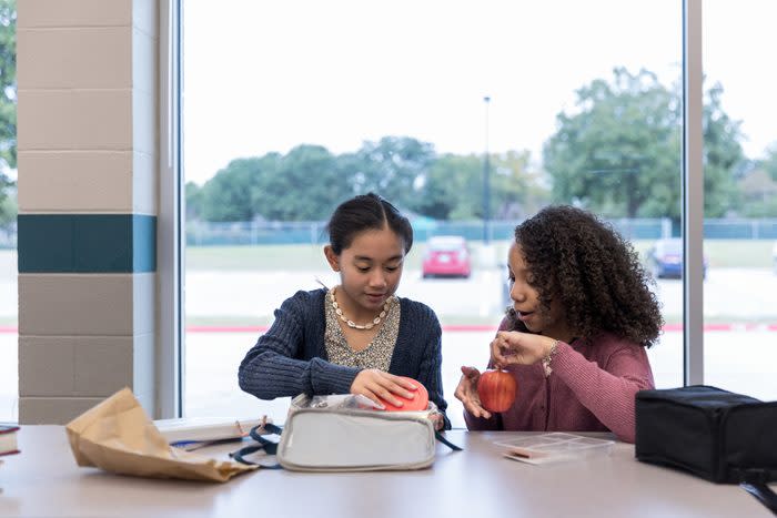 Preteen girl shares lunch with a friend