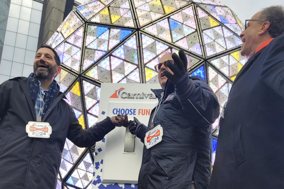 From left, Josh Weinstein, President, CEO, and Chief Climate Officer of Carnival Corporation, Tom Harris, President of the Times Square Alliance and Jeffrey Straus, President of Countdown Entertainment prepares to push the switch to test the Times Square ball on Saturday, Dec. 30, 2023, for annual New Year's Eve ball drop in New York. With throngs of revelers set to usher in the new year under the bright lights of Times Square, officials and organizers say they are prepared to welcome the crowds and ensure their safety. (AP Photo/Julie Walker)