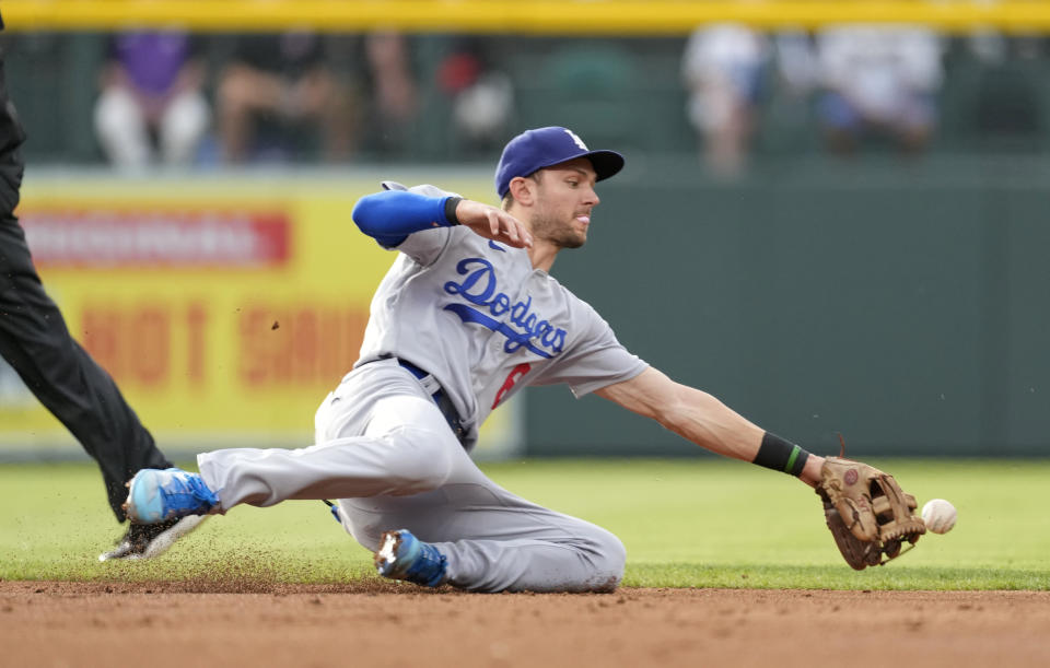 Los Angeles Dodgers shortstop Trea Turner dives for a ground ball off the bat of Colorado Rockies' Connor Joe during the first inning of a baseball game Monday, June 27, 2022, in Denver. (AP Photo/David Zalubowski)