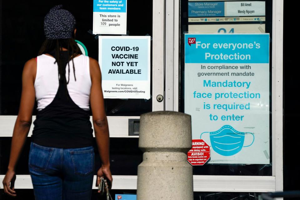 A customer walks past a sign on Dec. 2 indicating a COVID-19 vaccine is not yet available at a Walgreens in Long Beach, California. States faced a deadline of Dec. 4 to place orders for the coronavirus vaccine as many reported record infections, hospitalizations and deaths, while hospitals were pushed to the breaking point with the worst feared yet to come.