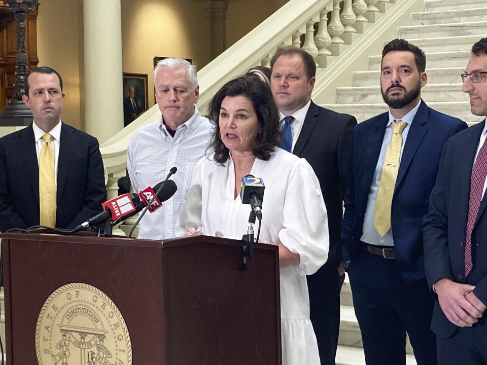 Dana Pope, flanked by her husband, second from left, and lawyers, speaks at a news conference at the Capitol in Atlanta, Thursday, Oct. 27, 2022. Her son Ethan was 23 when he died in December 2021 after using kratom. His parents have filed a wrongful death lawsuit against about a dozen people, companies and organizations connected to the manufacture, marketing and sale of the herbal supplement. (AP Photo/Kate Brumback)