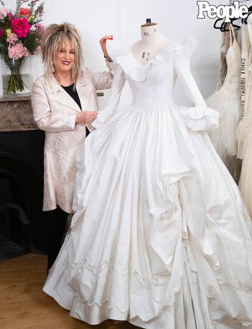 <p>Lauren Fleishman</p> Elizabeth Emanuel poses with her recreated spare wedding dress for Princess Diana in London on March 7, 2024