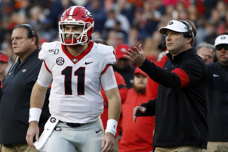 Georgia quarterback Jake Fromm (11) talks with head coach Kirby Smart during the first half of an NCAA college football game, Saturday, Nov. 16, 2019, in Auburn, Ala. (AP Photo/Butch Dill)