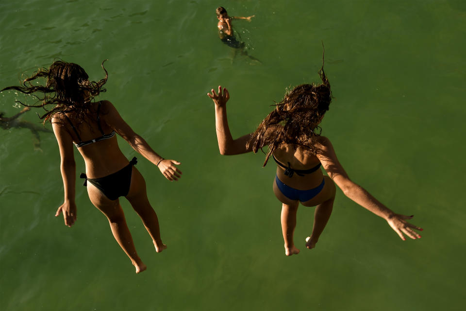 <p>Two women jump from a platform over the water at La Concha beach during a hot summer day in the basque city of San Sebastian, northern Spain, Friday, Aug. 3, 2018. (Photo: Alvaro Barrientos/AP) </p>