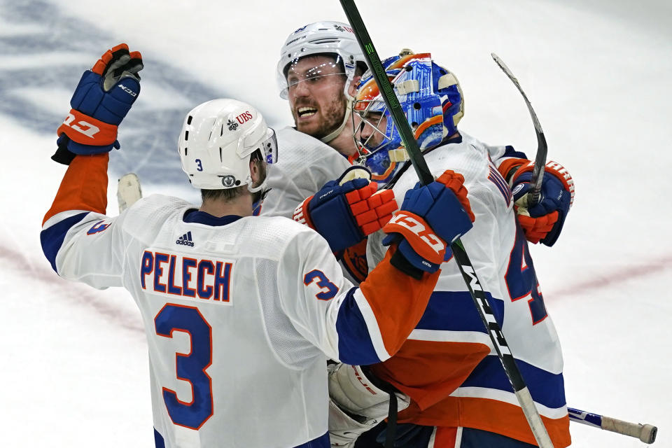 New York Islanders center Casey Cizikas (53) and defenseman Adam Pelech (3) celebrate with Islanders goaltender Semyon Varlamov (40) after they defeated the Boston Bruins 5-4 in Game 5 of an NHL hockey second-round playoff series, Monday, June 7, 2021, in Boston. (AP Photo/Elise Amendola)