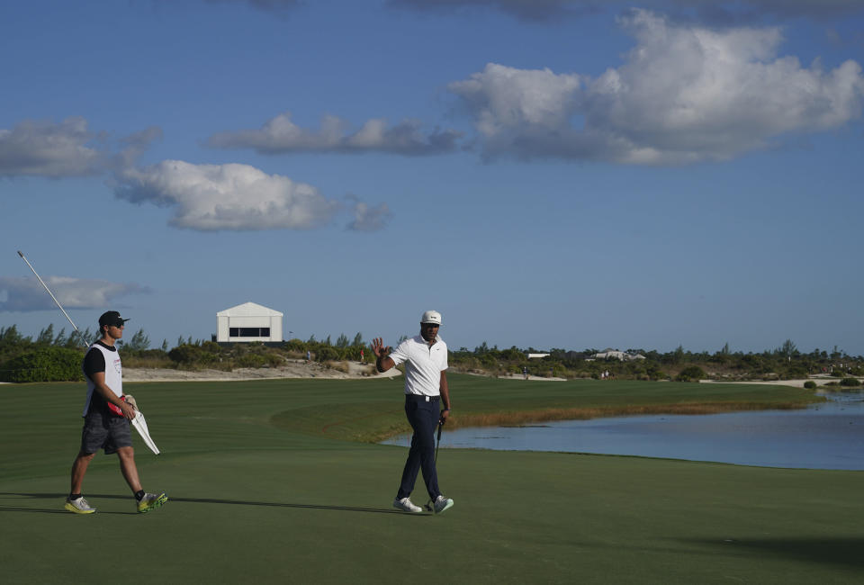Tony Finau, of the United States, right, celebrates after sinking a birdie on the 18th hole during the second round of the Hero World Challenge PGA Tour at the Albany Golf Club, in New Providence, Bahamas, Friday, Dec. 3, 2021.(AP Photo/Fernando Llano)