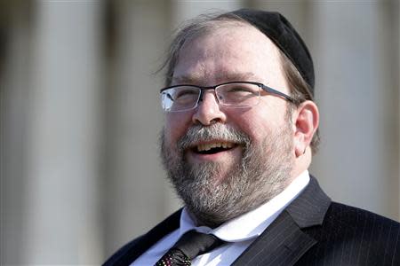 Rabbi Binyomin Ginsberg smiles as he talks to reporters about his case, in which he sued Northwest Airlines for breach of contract after the airline said he had abused their frequent flyer program, following arguments before the U.S. Supreme Court in Washington December 3, 2013. REUTERS/Jonathan Ernst