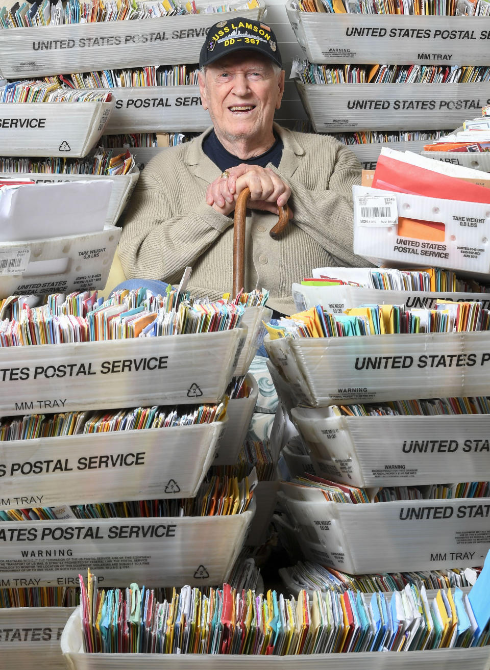 In this Tuesday, Jan. 8, 2019 photo, Duane Sherman, 96, poses with a small fraction of the 50,000 birthday cards he's received after his daughter asked people to send him cards to cheer him up on his birthday at his home in Fullerton, Calif. (Kevin Sullivan/The Orange County Register via AP)