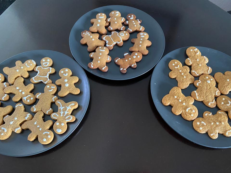three plates with decorated gingerbread cookies on them