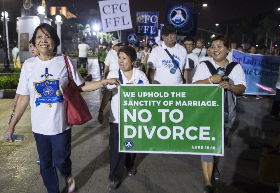 File: Filipino Catholic worshipers hold a banner as they take part in a march for life in a park in Manila (AFP via Getty Images)