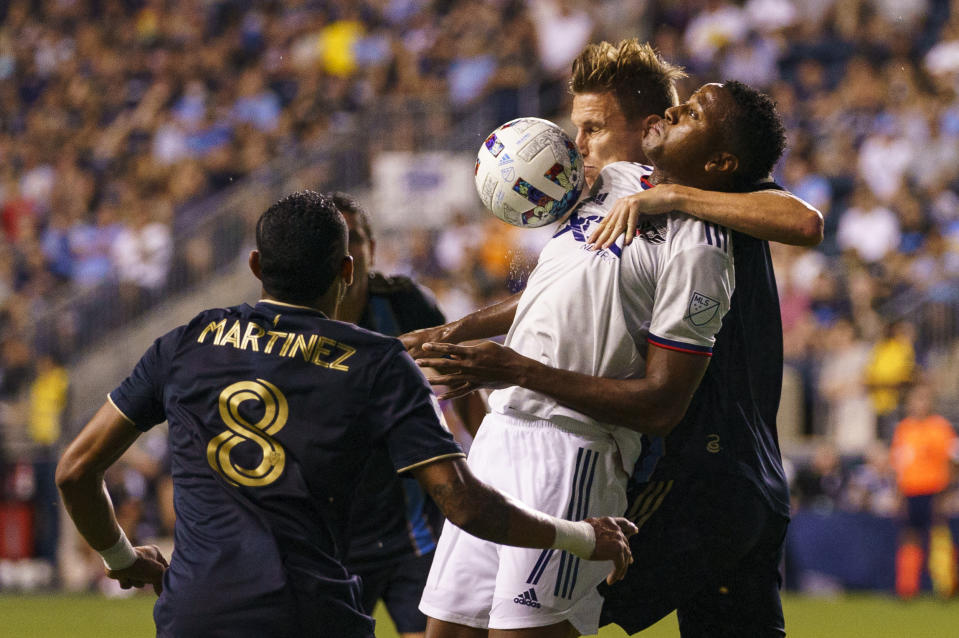 D.C. United's Michael Estrada, center, chests the ball as Philadelphia Union's Jack Elliott, right, pulls him back during the second half of an MLS soccer match Friday, July 8, 2022, in Chester, Pa. The Union won 7-0. (AP Photo/Chris Szagola)