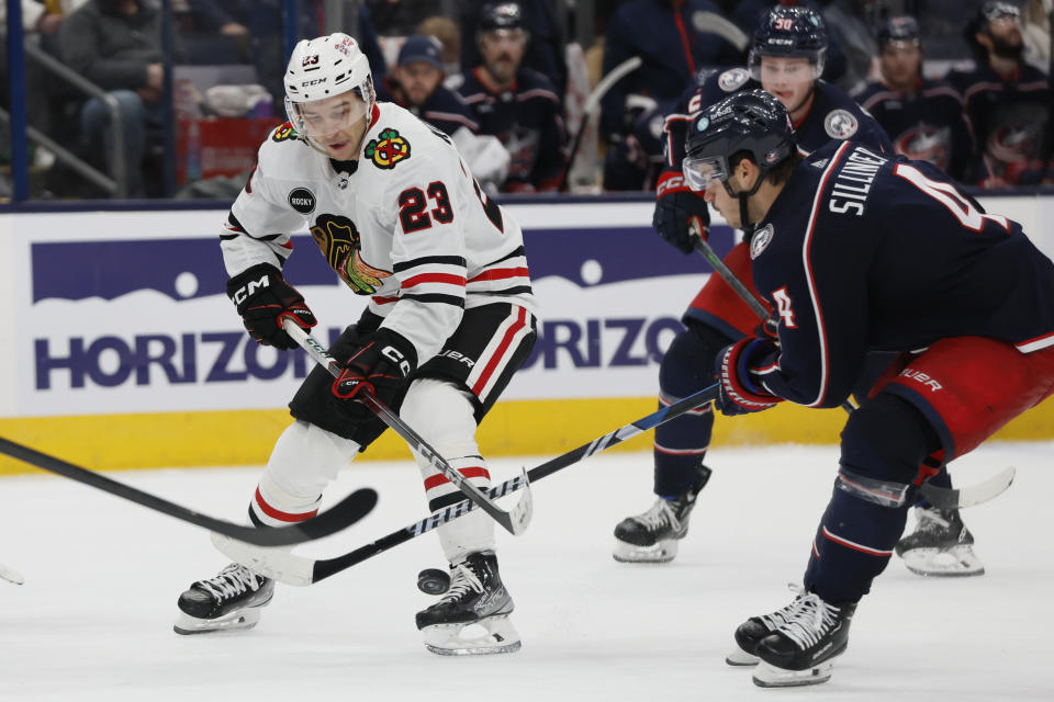 Chicago Blackhawks' Philipp Kurashev, left, tries to control the puck as Columbus Blue Jackets' Cole Sillinger defends during the third period of an NHL hockey game Wednesday, Nov. 22, 2023, in Columbus, Ohio. (AP Photo/Jay LaPrete)