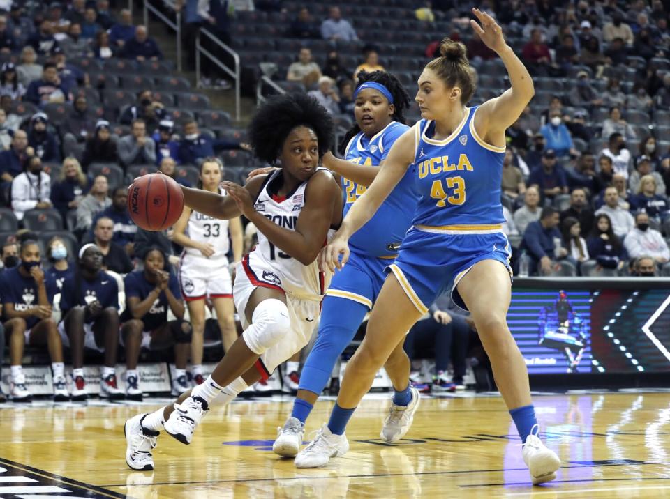 Connecticut guard Christyn Williams, left, drives against UCLA forward Izzy Anstey on Dec. 11.