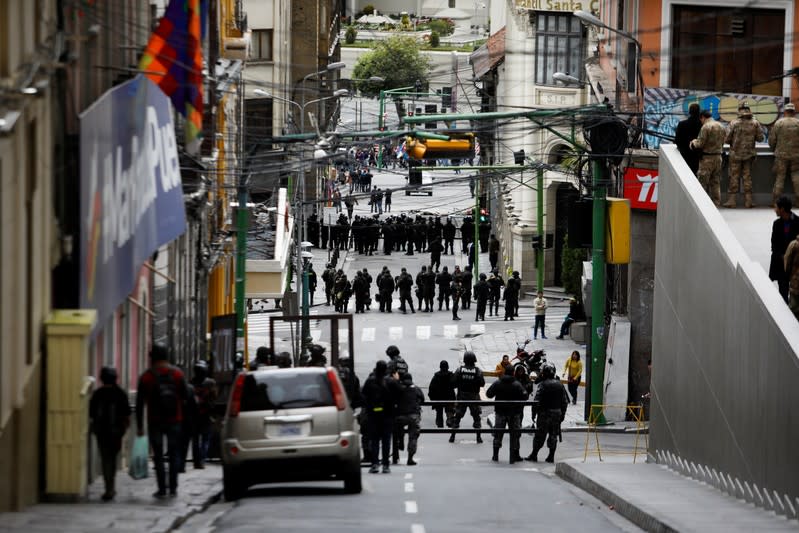 Members of the security forces stand guard as supporters of Bolivia's ousted President Evo Morales take part in a protest, in La Paz