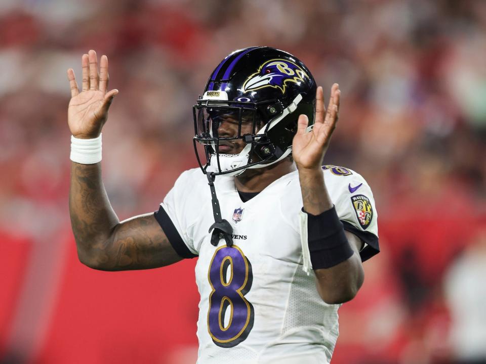 Lamar Jackson holds up two hands during a Ravens game.