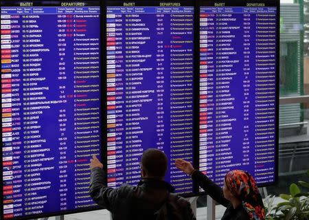 FILE PHOTO - Passengers check the departure board at the Domodedovo Airport outside Moscow, Russia September 28, 2017. REUTERS/Tatyana Makeyeva