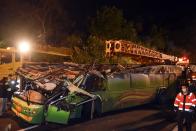 In this photo released by Xinhua News Agency, rescuers work near the wreckage of a crashed tourist bus on a highway in Taipei, Taiwan Tuesday, Feb. 14, 2017. The bus carrying Taiwanese tourists on a trip to view cherry blossoms flipped over on an expressway ramp in Taiwan's capital on Monday, killing more than 30 people and injuring many others, officials said. (Ou Dongqu/Xinhua via AP)