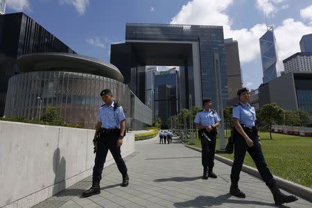 Policemen patrol outside Legislative Council (L) and government headquarters (back) in Hong Kong, China June 16, 2015. REUTERS/Bobby Yip