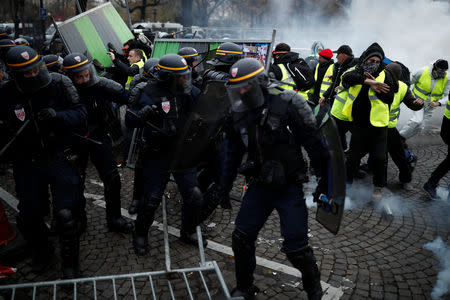 Protesters wearing yellow vest, a symbol of a French drivers' protest against higher fuel prices, clash with riot police on the the Champs-Elysee in Paris, France, November 24, 2018. REUTERS/Benoit Tessier