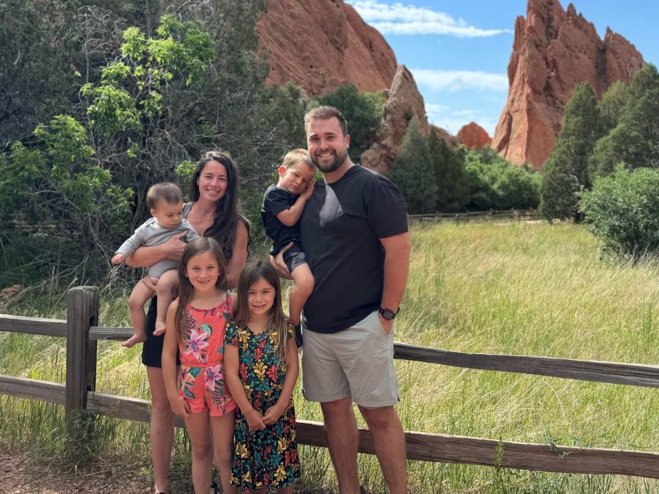 Matt Krueger with his wife and four children standing in front of a rock formation at at Garden of the Gods in Colorado Springs.