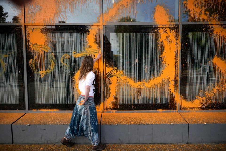 Lucy Hammil smears the orange paint that she sprayed over the Alan Gilbert Building at Manchester University (Christopher Furlong / Getty Images)